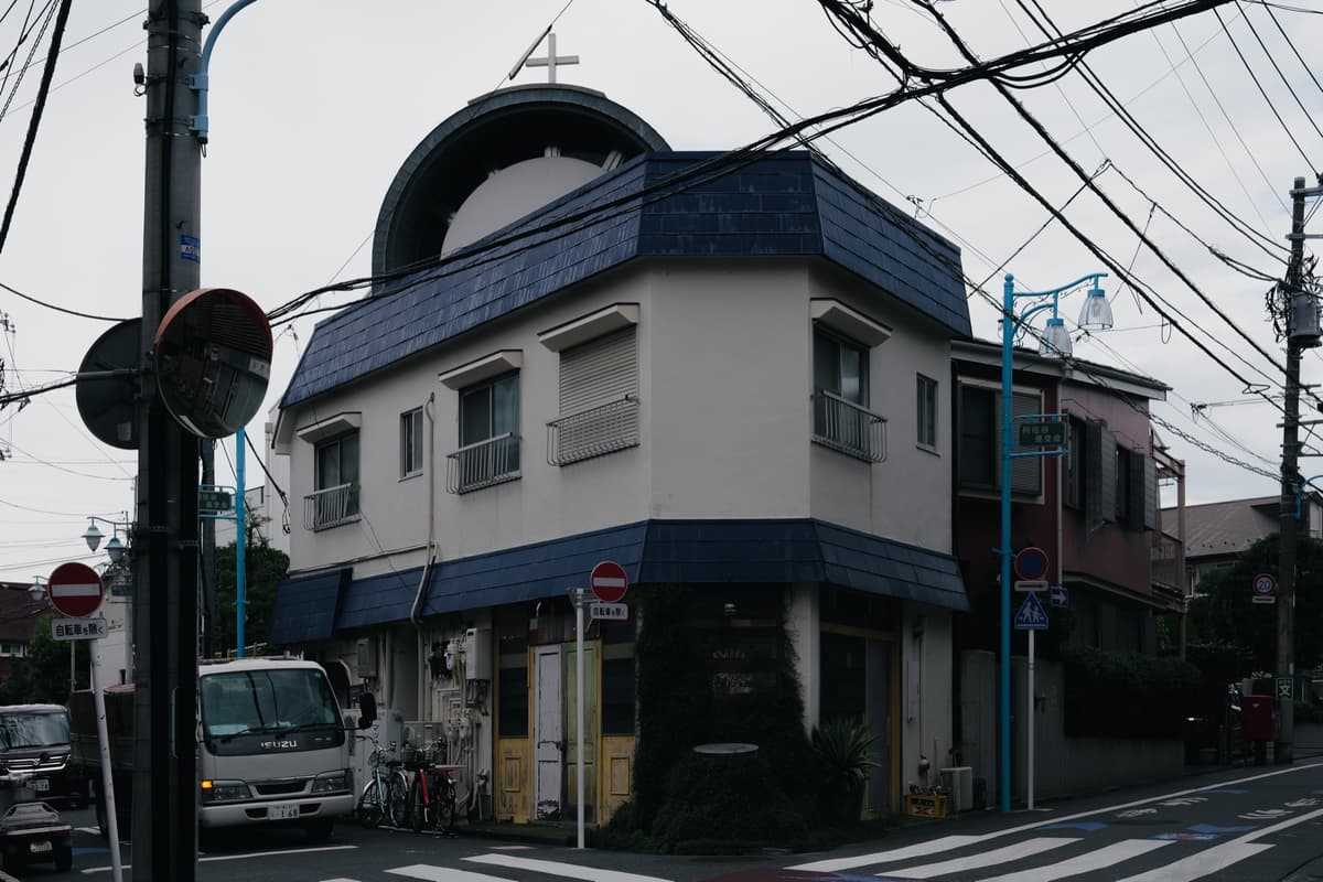 丸窓と紺屋根の角家