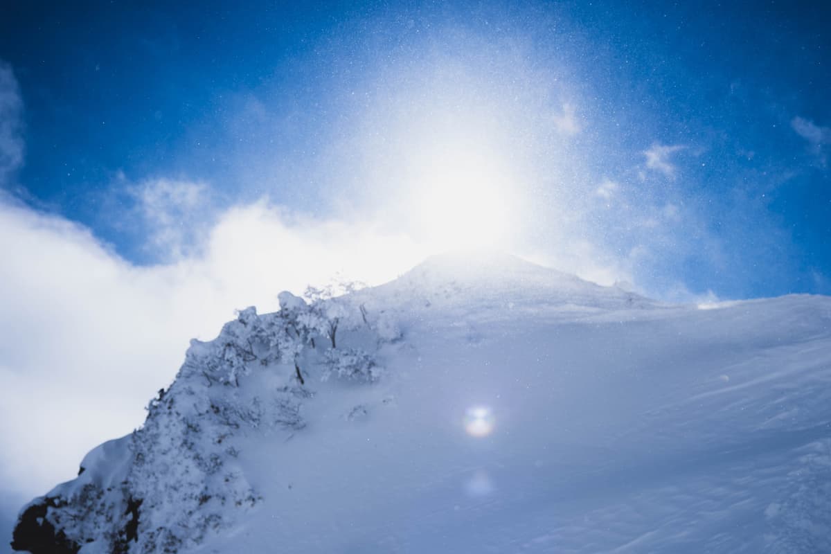 陽を浴びる雪煙と稜線