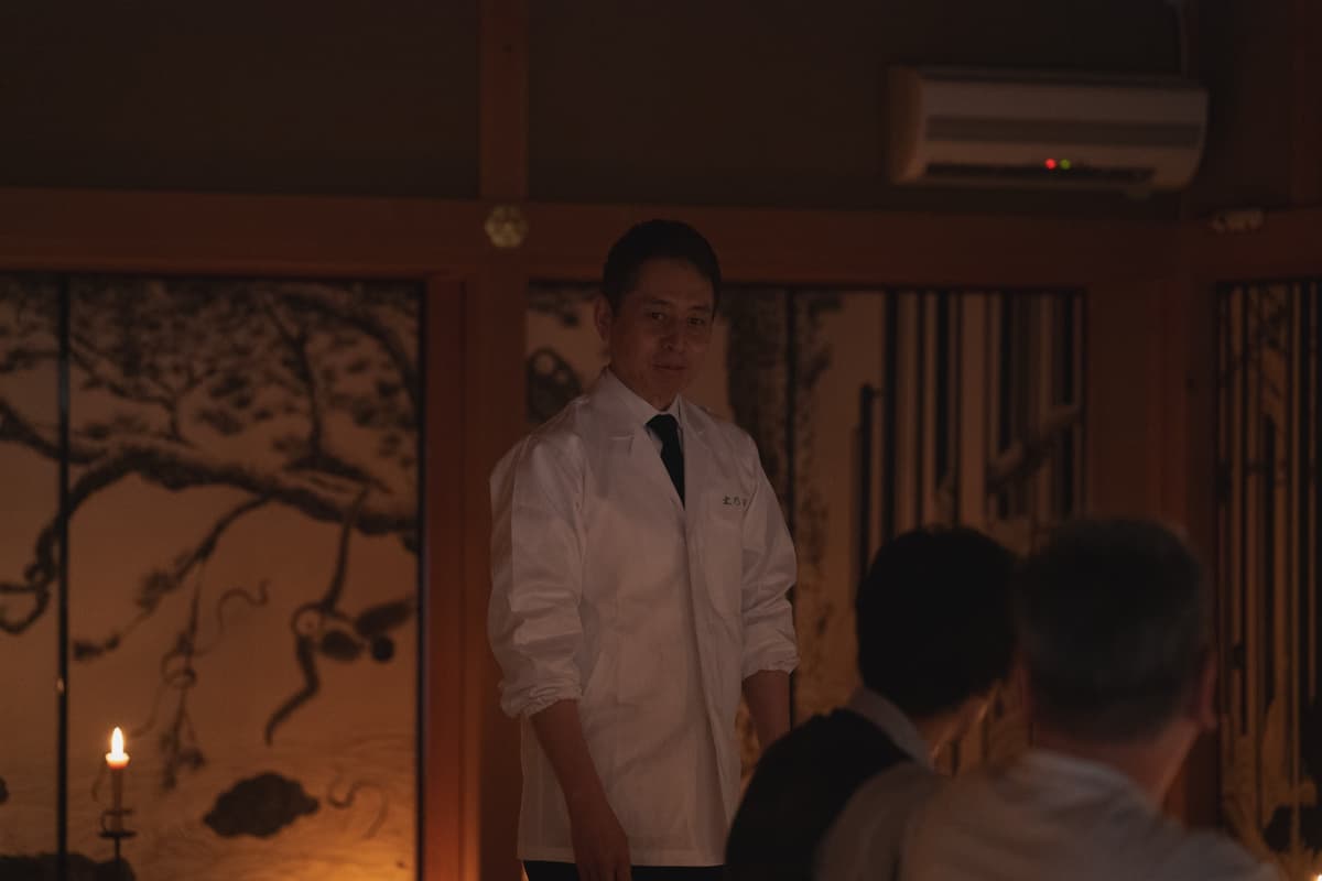 屏風の前に立つ白衣