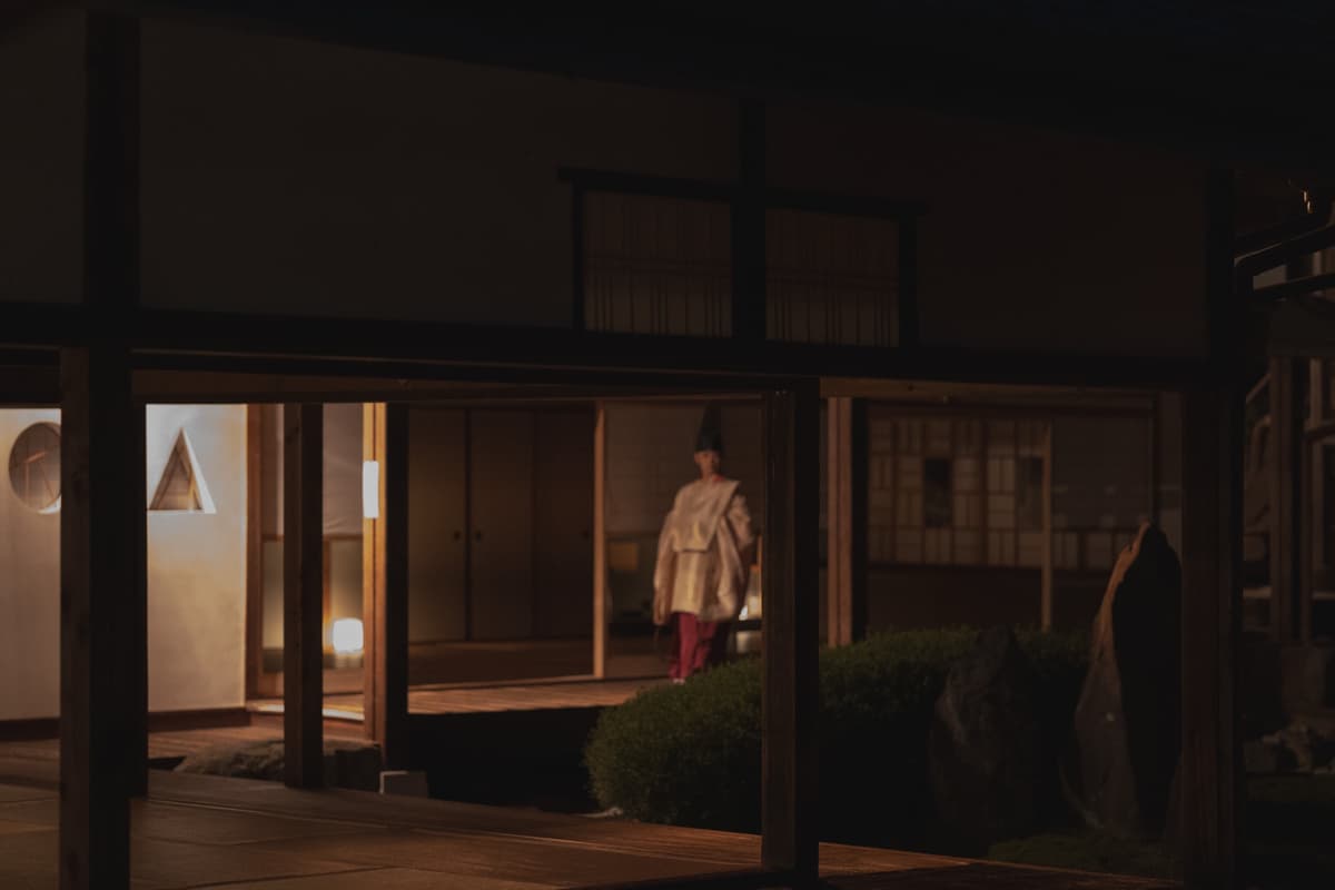 灯りの中を歩く白い衣